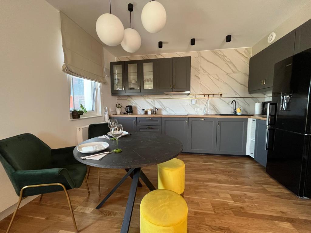 a kitchen with a table and a black refrigerator at Halo Apartments in Wrocław