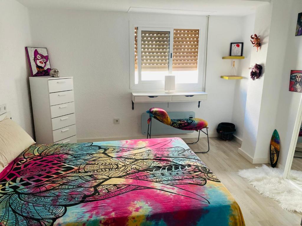 ein Schlafzimmer mit einem farbenfrohen Bett und einem Stuhl in der Unterkunft Calle oriente in Valencia