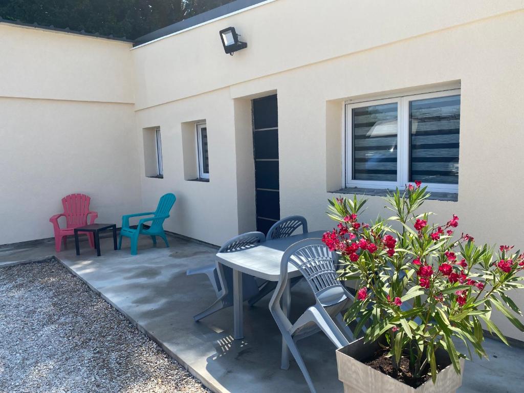 a patio with chairs and a table and flowers at BeautifulLoft près Disneyland/Astérix/Aéroport CDG in Claye-Souilly