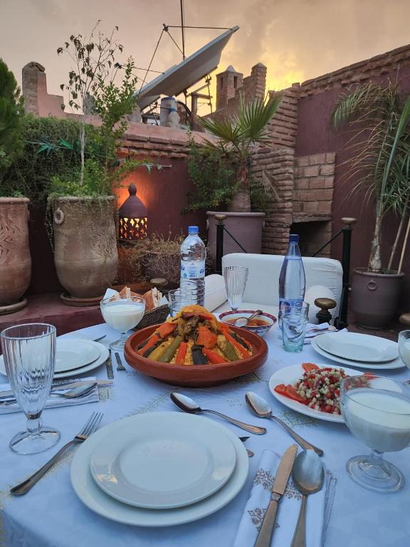 a table with white plates of food on it at Riad Assalam in Marrakech