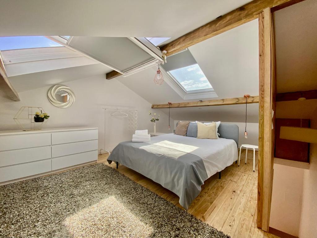 um quarto com uma cama e uma clarabóia em Casinha da Patricia na Nazaré