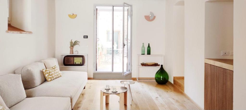 ein Wohnzimmer mit einem Sofa und einem Tisch in der Unterkunft Casa Primo in Cortona