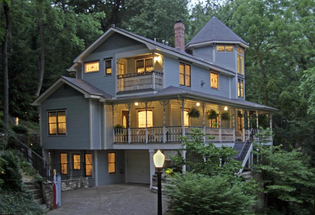 a large blue house with its lights on at Arsenic and Old Lace Bed & Breakfast Inn in Eureka Springs