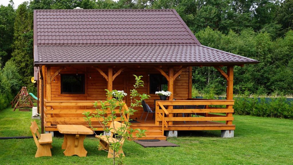 uma cabina de madeira com uma mesa e um banco em Zacisze Choczewo em Choczewo