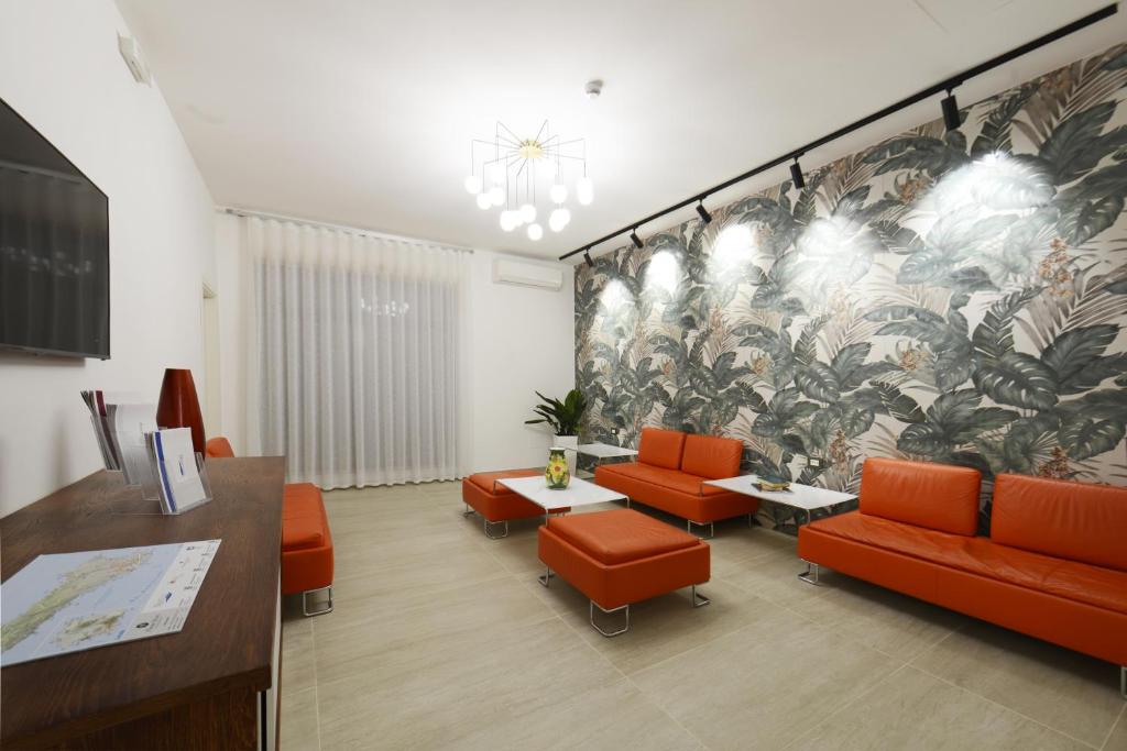a waiting room with orange chairs and a mural at Best Western Hotel Martello in Lampedusa