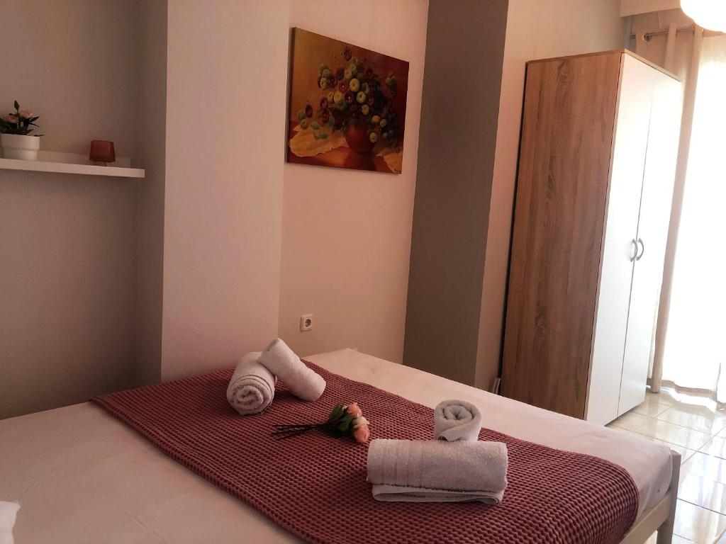 Un dormitorio con una cama con toallas. en Pink Rose Apartment, en Nea Peramos