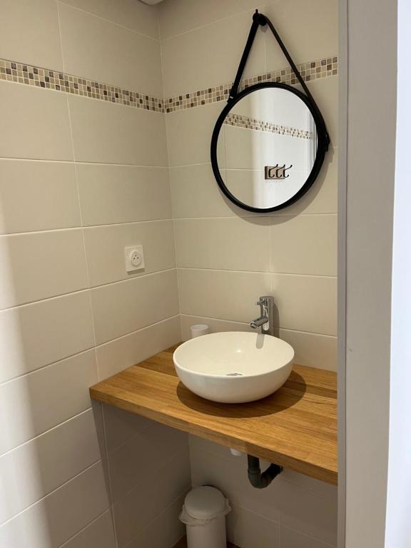 a bathroom with a white sink and a mirror at Studio Cosy in Concarneau