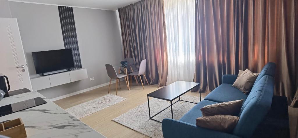 sala de estar con sofá azul y TV en EM02- Apartament 2 camere luxury, en Târgu Jiu