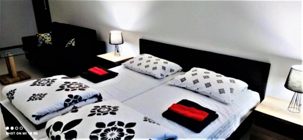 a bedroom with two beds with black and white pillows at Pokoje KRASKA 36 in Łomża