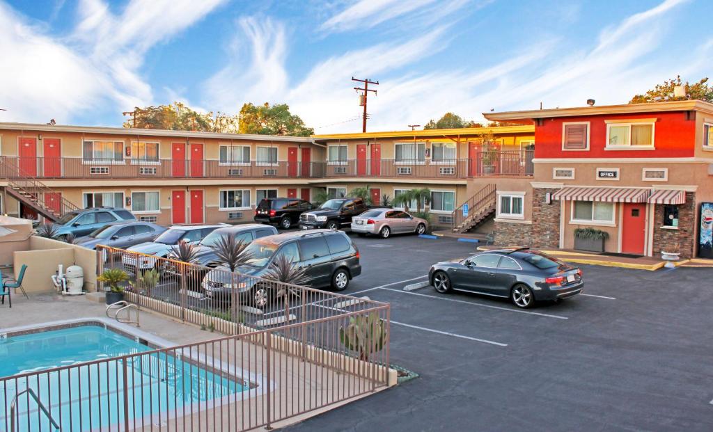 a parking lot with cars parked in front of a building at Friendly Hills Inn in Whittier