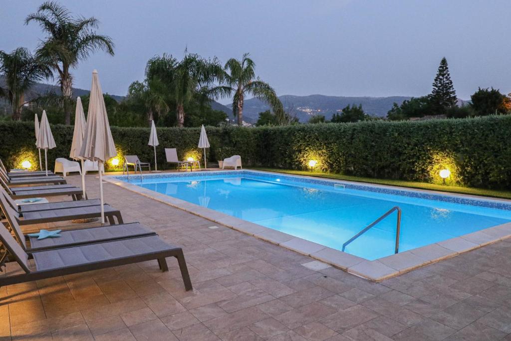 uma piscina com cadeiras e guarda-sóis num resort em B&B Il Girasole em Capo dʼOrlando