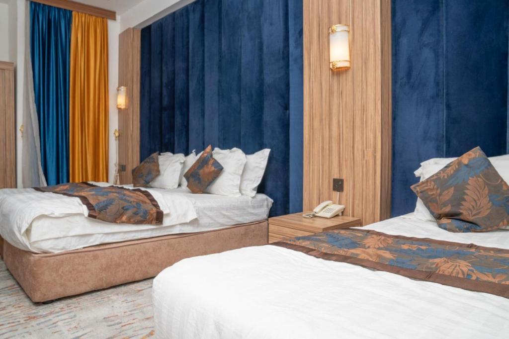 um quarto de hotel com duas camas e um telefone em Karbala blazma em Karbala
