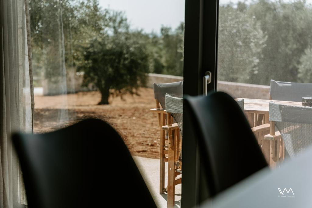 a view of a table and chairs through a window at Elaionas Estate Perdika in Perdika