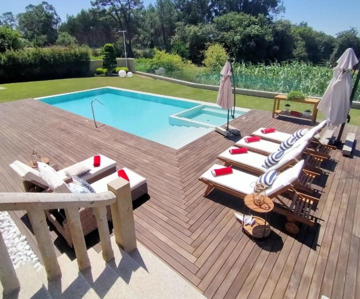 een zwembad met stoelen en een tafel en een zwembad bij Capricho de Fontabrón in Vilagarcia de Arousa
