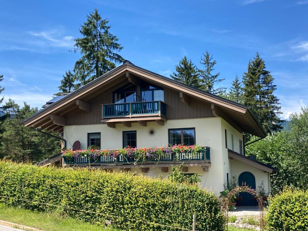 una casa con balcón y flores. en Haus Waldfrieden, en Bischofswiesen