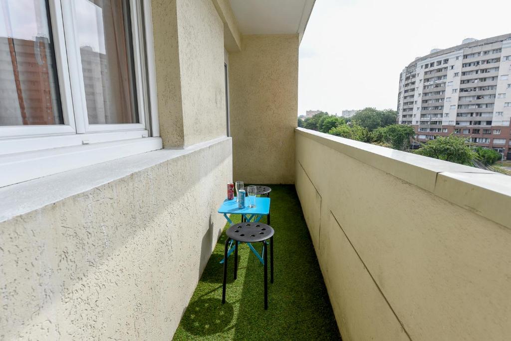 une petite table bleue assise sur le côté d'une fenêtre dans l'établissement Superbe 2 pièces - proche de Paris, à Villeneuve-la-Garenne