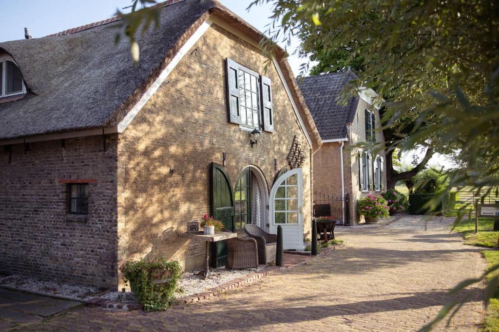 ein altes Backsteinhaus mit einer Veranda und einer Auffahrt in der Unterkunft de Bieslandse Heerlijkheid in Delft