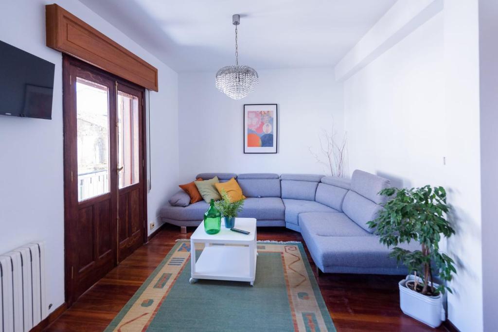 Cuntis的住宿－Luminoso apartamento reformado en villa termal，客厅配有蓝色的沙发和桌子