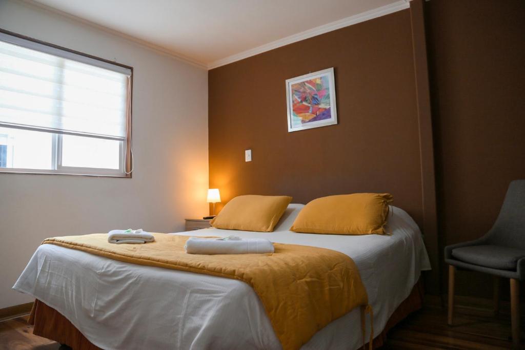 a bedroom with a bed with two towels on it at Aparthotel Don Alonso in Antofagasta