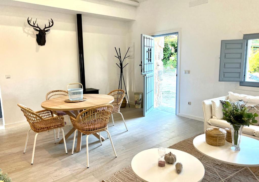 ein Wohnzimmer mit einem Tisch und Stühlen in der Unterkunft Casa rural La Casona de Monterrey in Venturada
