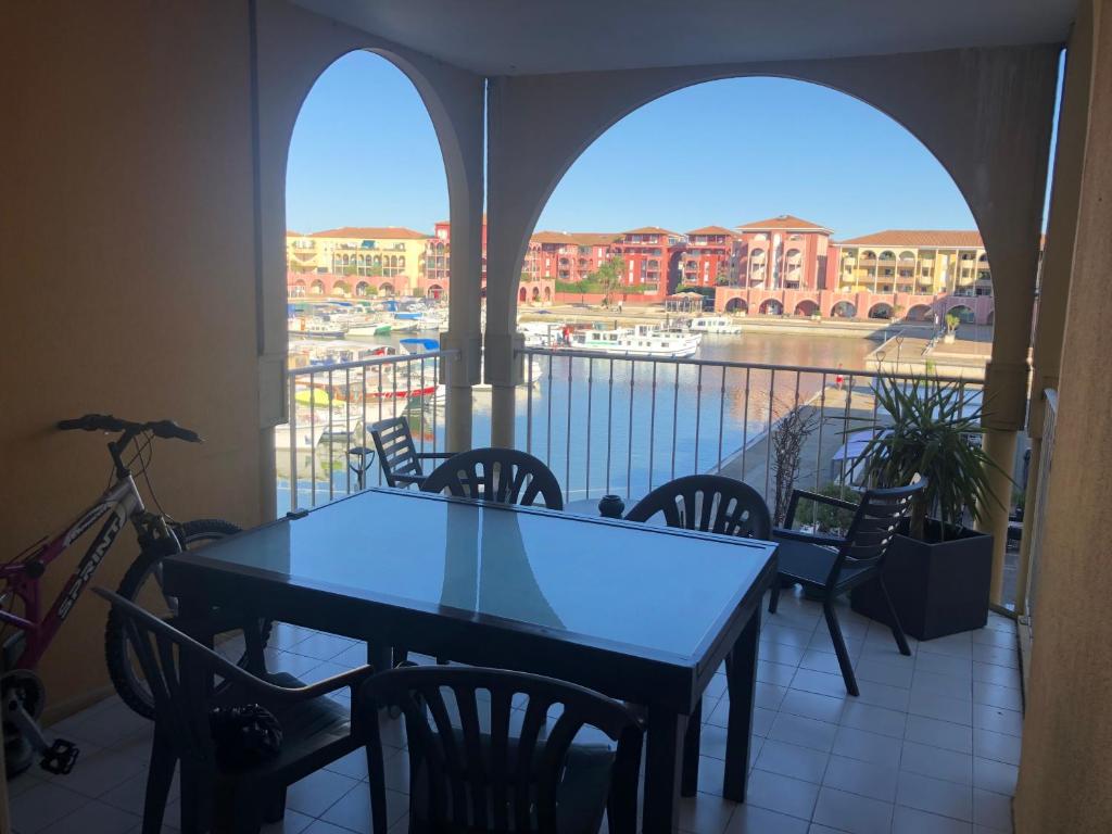 a table and chairs on a balcony with a view at Chambre dans appartement avec vue sur le port in Lattes