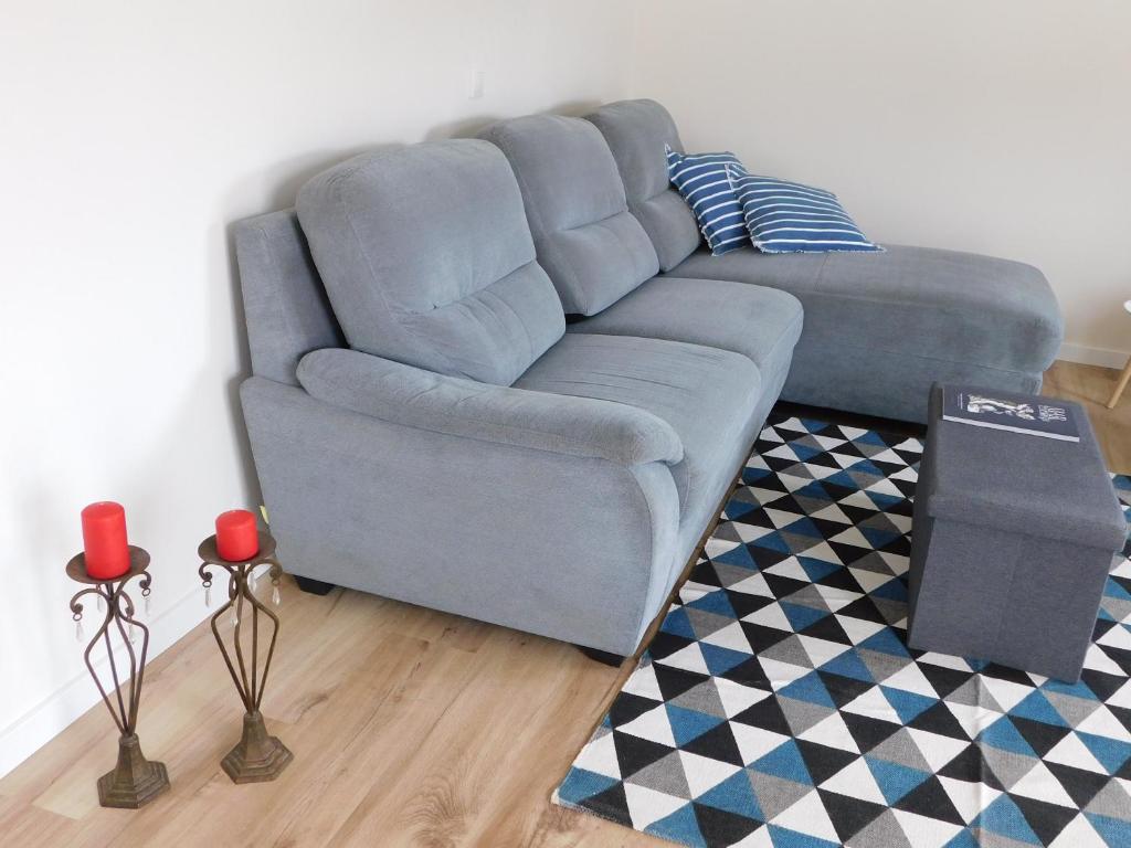 Sofá azul en la sala de estar con alfombra en NiaAzoreanApartments2, aconchegante e confortável! en Horta