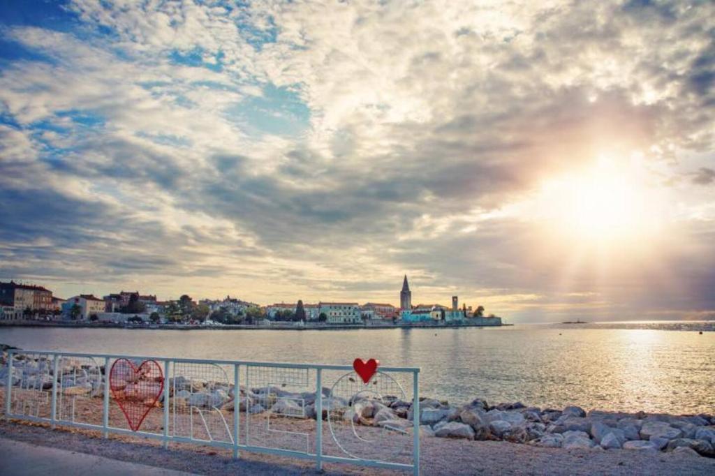 a heart sign on a fence near a body of water at San Eleuterio Guesthouse in Poreč