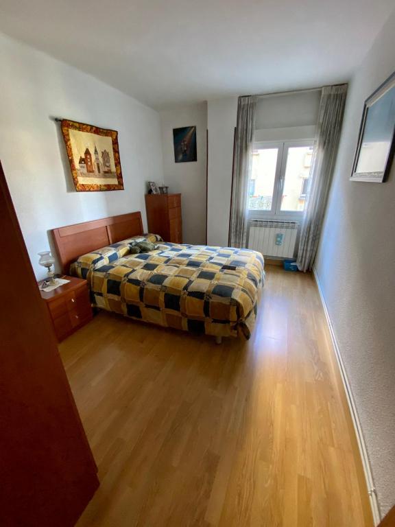 een slaapkamer met een bed en een houten vloer bij APARTAMENTO CENTRO BURGOS in Burgos