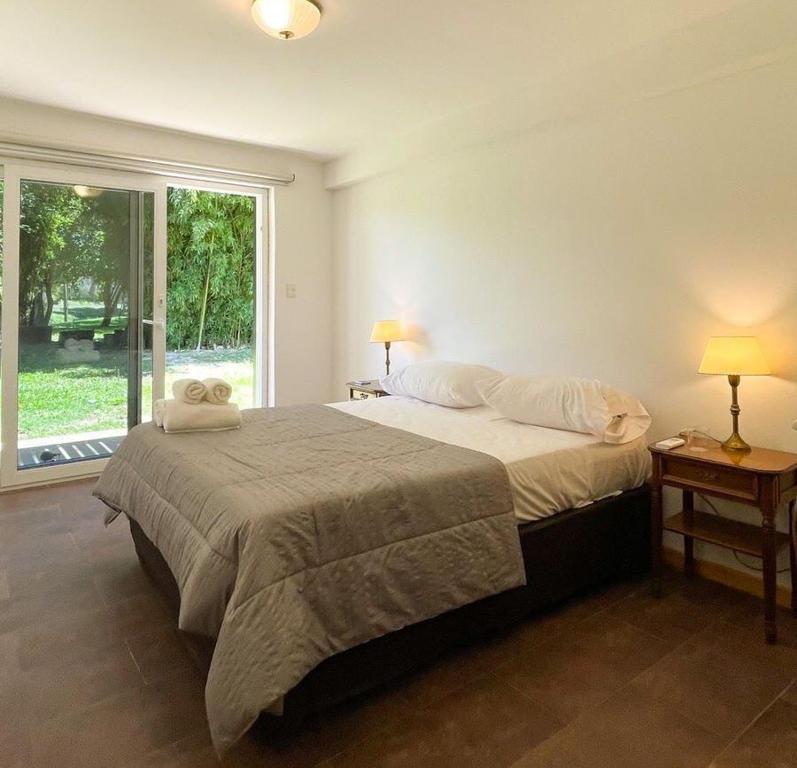 a bedroom with a bed with two lamps and a window at Senador Dupont in Tigre