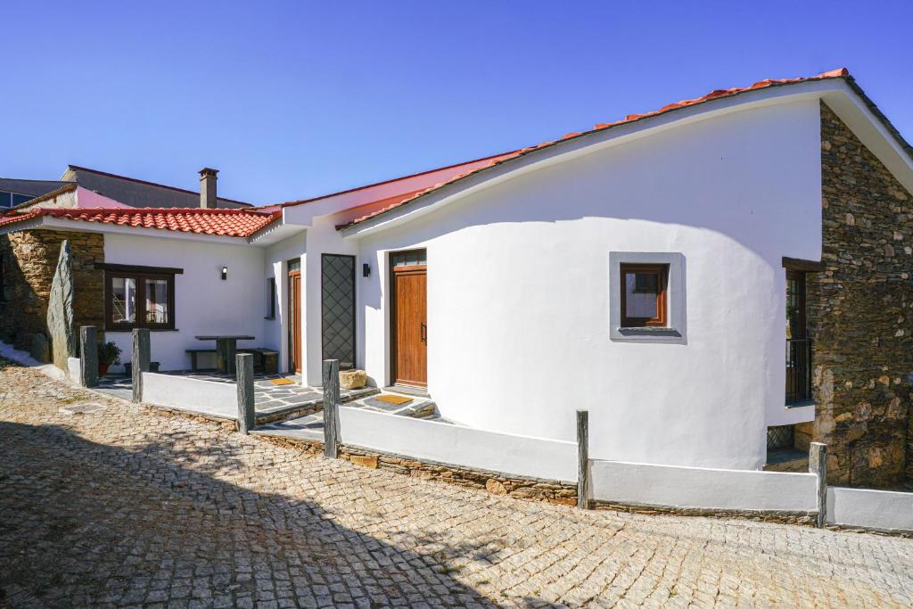 uma casa branca com uma entrada de tijolos em Casa do Fincão em Bragança