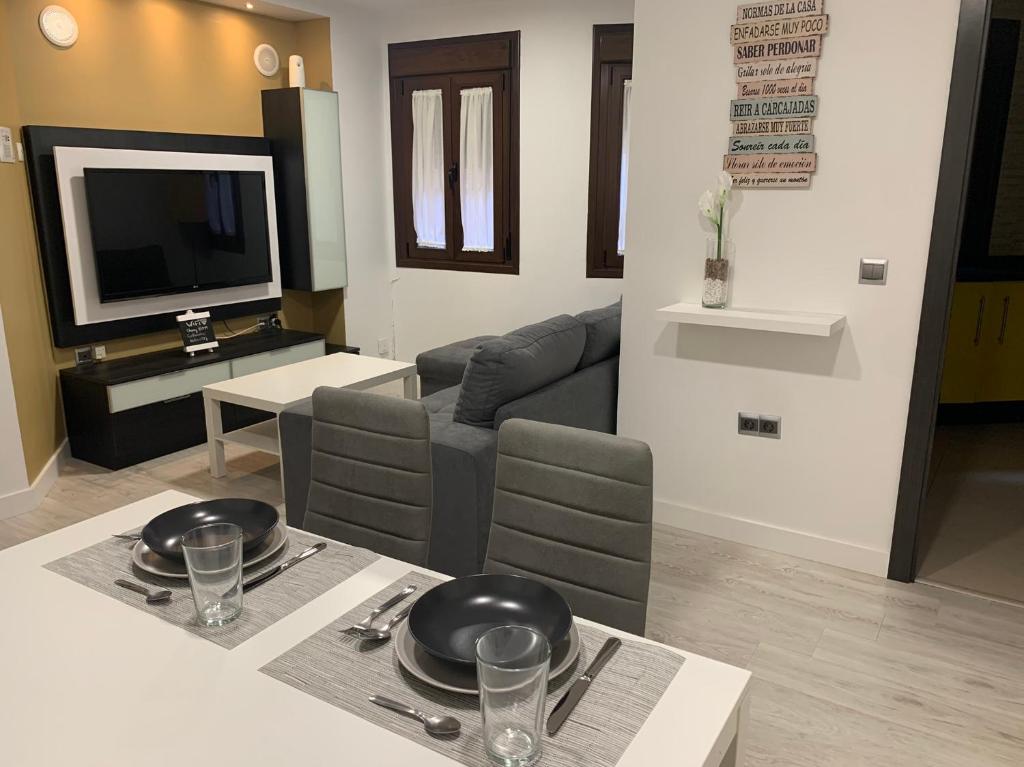 ein Wohnzimmer mit einem Tisch und einem Sofa in der Unterkunft APARTAMENTO LAS NIÑAS in Ronda