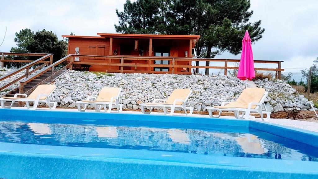 una piscina con sedie e una casa sullo sfondo di Quinta da Sonia, Melides a Melides