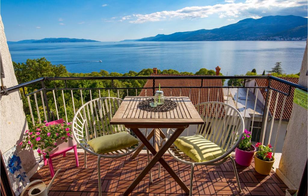 a table and chairs on a balcony with a view of the water at 2 Bedroom Gorgeous Apartment In Rijeka in Rijeka