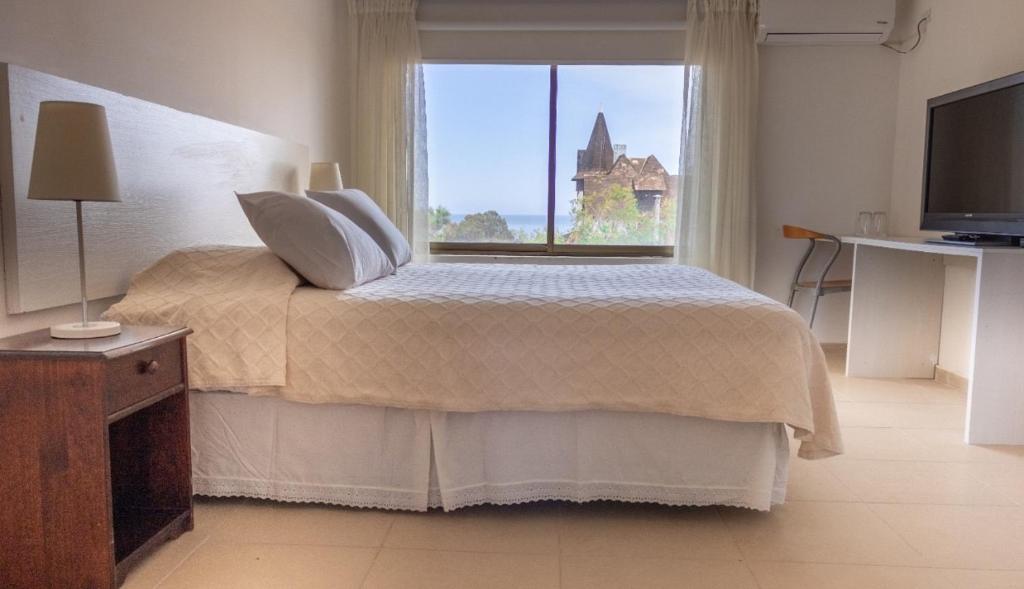 a bedroom with a bed and a large window at Hotel Carande in Papudo