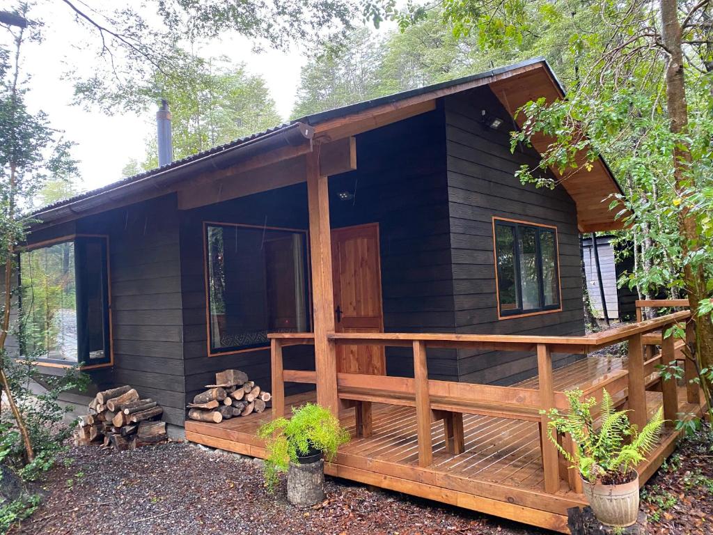 eine Blockhütte mit einer Veranda und einer Terrasse in der Unterkunft Cabaña nueva en Pucón in Pucón