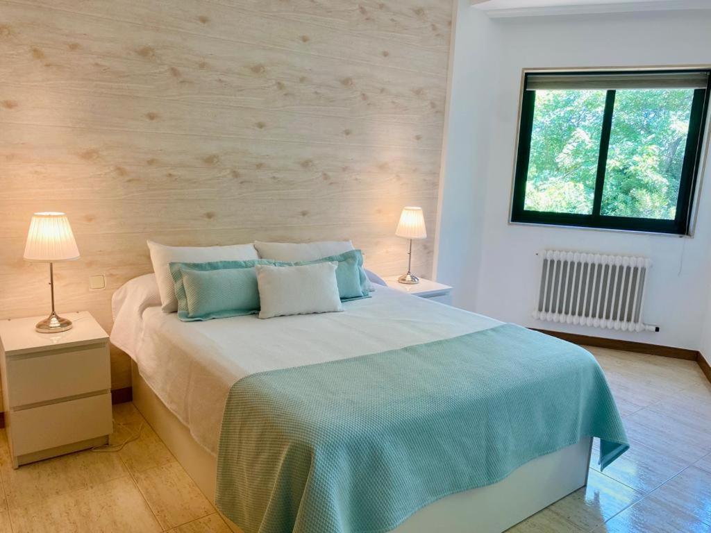 1 dormitorio con 1 cama grande y 2 lámparas en Apartamento en Samil, en Vigo