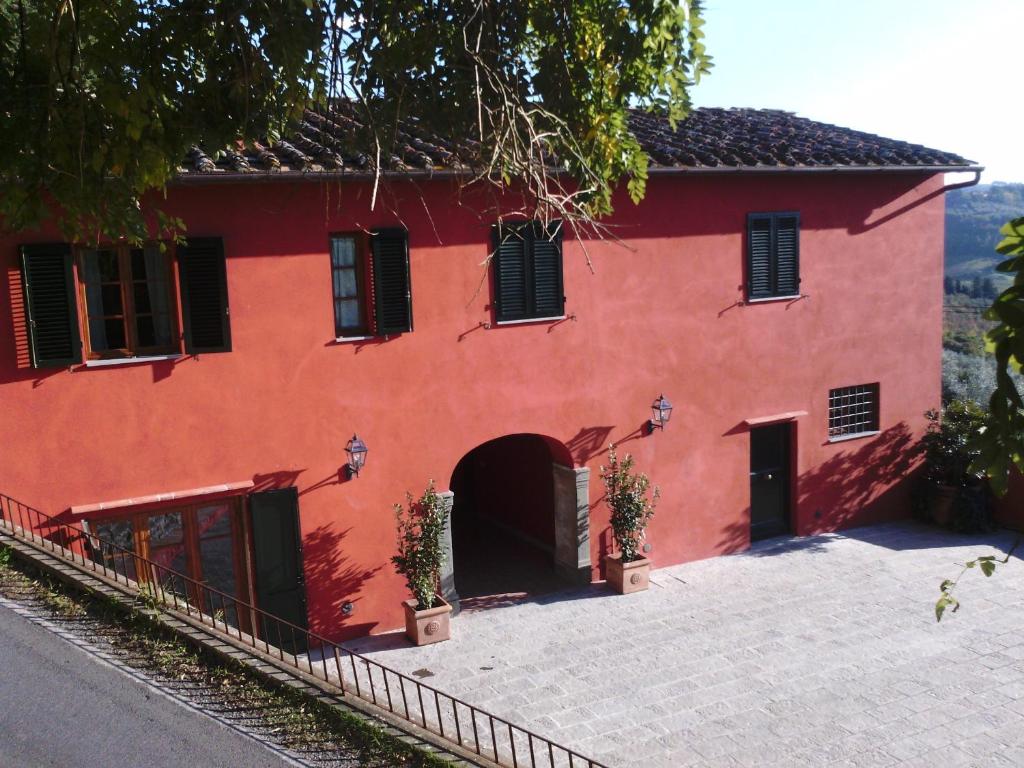 une maison rouge avec une allée devant elle dans l'établissement Le Valli Lavanda, à San Casciano in Val di Pesa
