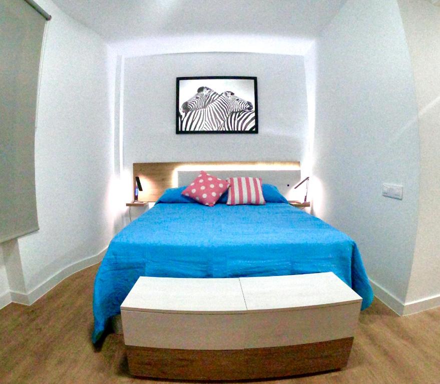 una camera con letto blu e 2 cuscini di DELUXE TRIANA CENTER a Siviglia