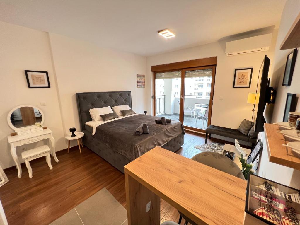 a bedroom with a bed and a living room at White Homes 16 - Master Quart in Podgorica