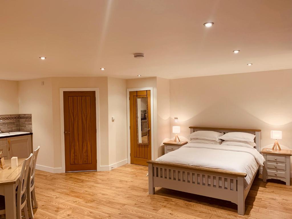 a bedroom with a bed and two tables and a desk at Plumptons Farm Holiday Lodges in Colchester