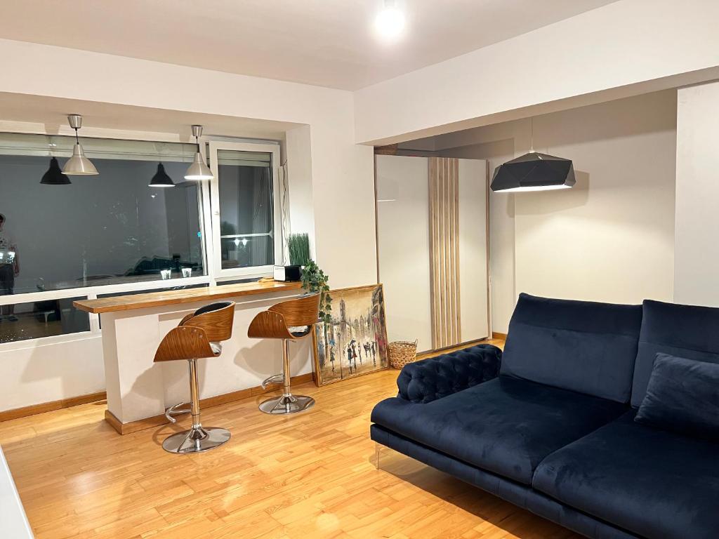 un soggiorno con un divano blu e una cucina di RIVER VIEW - Izvor Studio a Bucarest