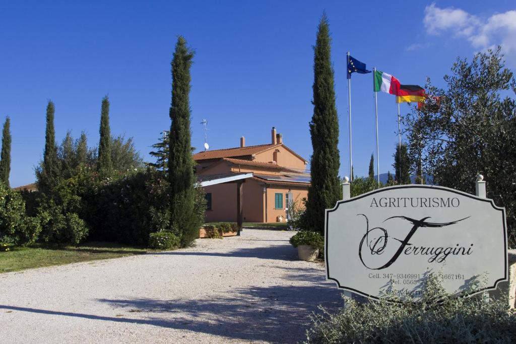 um sinal em frente a uma casa com uma bandeira em Agriturismo Ferruggini em Bolgheri