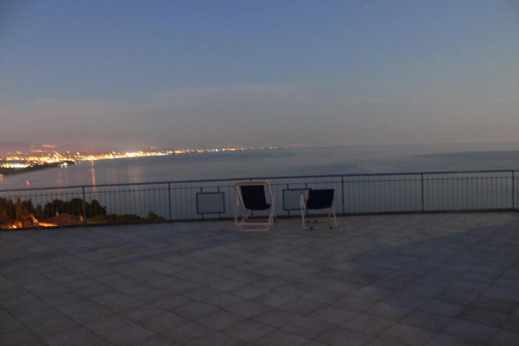 two chairs sitting on top of a balcony overlooking the water at Hotel Conca d'Oro in Stalettì