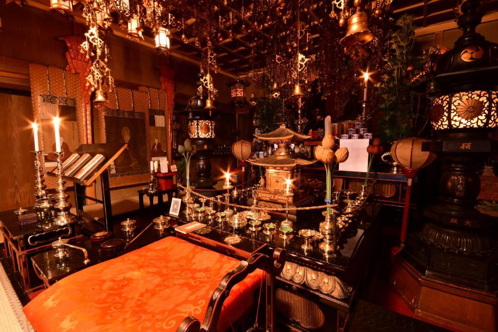 高野山的住宿－高野山 宿坊 宝城院 -Koyasan Shukubo Hojoin-，一间设有桌子、钢琴和灯的房间