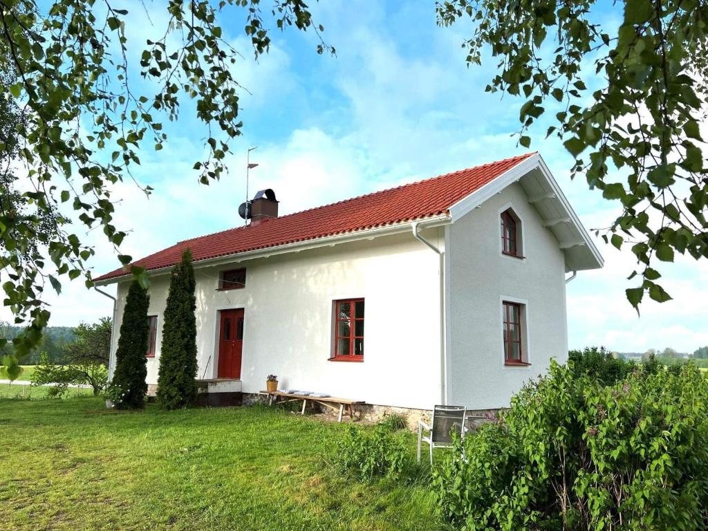 una casa blanca con techo rojo en un campo en Holiday home HOVA IV, en Hova