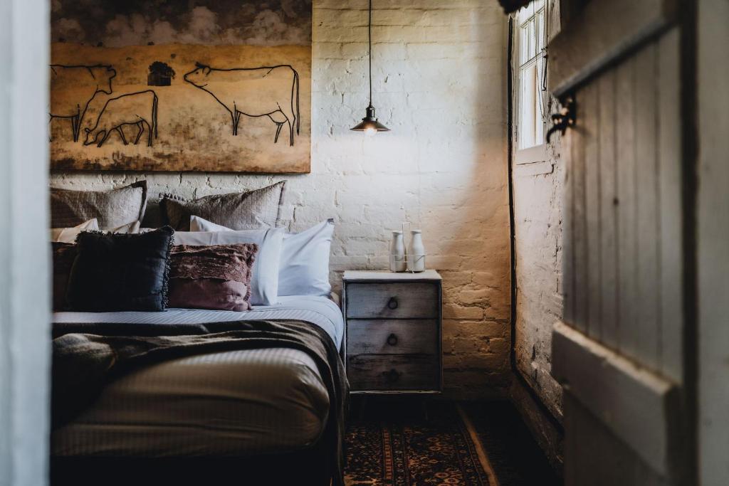 a bedroom with a bed and a painting on the wall at The Dairy in Castlemaine