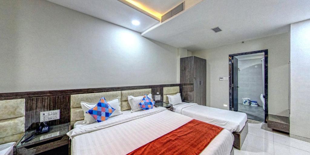 een slaapkamer met 2 bedden en een inloopdouche bij The Aanandam Hotel Resort in Itārsi