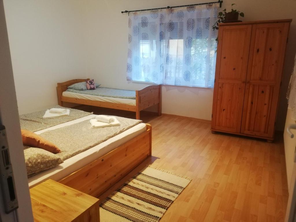 sypialnia z 2 łóżkami pojedynczymi i oknem w obiekcie Bagolylak Vendégház Siófok w Siófoku