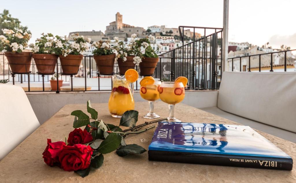 a table topped with bottles of wine and a vase filled with flowers at Apartamentos Mariano in Ibiza Town