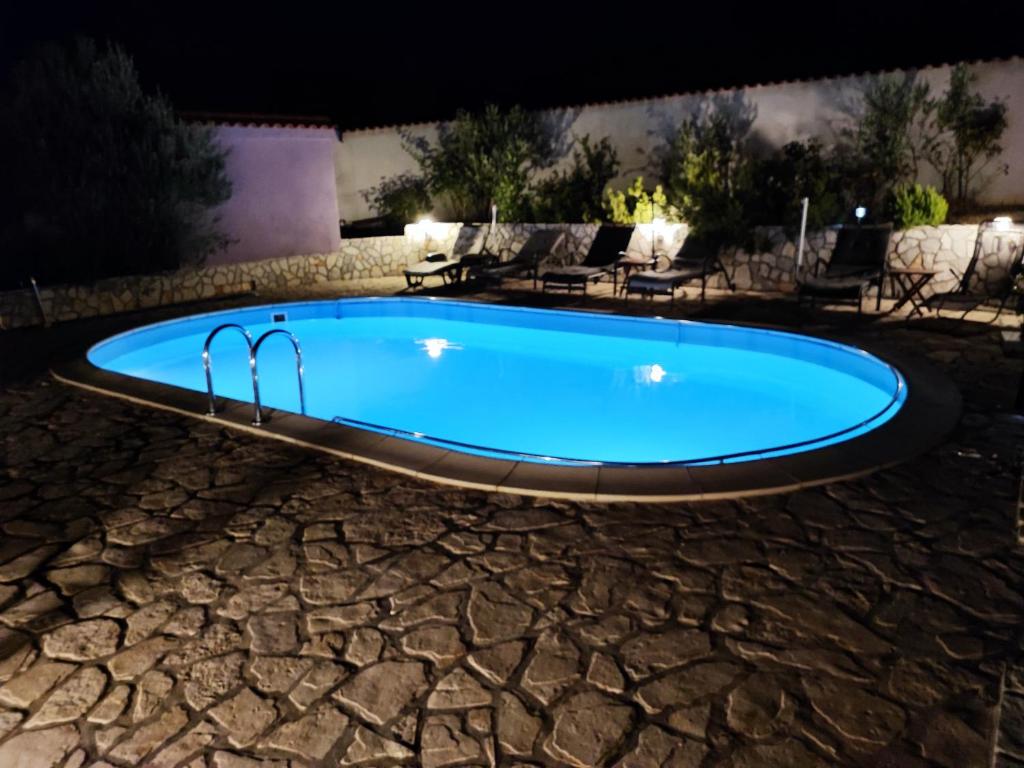 una piscina en un patio por la noche en Apartmani Sabira en Novi Vinodolski